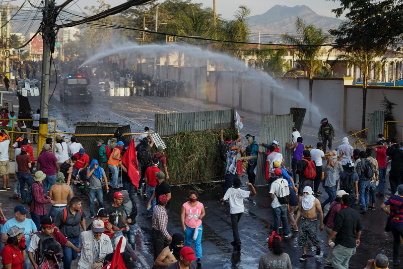 In Tegucigalpa, thousands Hondurans took to the streets this Friday protesting the reelection of Juan Orlando Hernandez. People bore 36 crucifix in commemoration of those who died since the elections. A small group of protesters damaged properties before clashing with the police. The Honduran Opposition Alliance Against the Dictatorship, Salvador Nasralla and Mel Zelaya, called the protest. In december 2017, OAS obserevers concluded new elections would be needed. À Tegucigalpa, des milliers de honduriens sont descendus dans la rue ce vendredi pour protester contre la réélection de Juan Orlando Hernandez. Des manifestants brandissaient 36 crucifix en mémoire des victimes de la crise électorale. Un petit groupe de manifestants a endomagé plusieurs bâtiments avant de faire face à la police. L’alliance opposée à la dictature, Salvador Nasralla, et Mel Zelaya sont à l’origine de la manifestation. En décembre 2017, les observateurs de l’OEA ont conclut que de nouvelles élections étaient de mise.